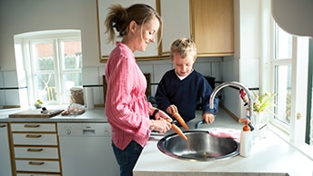une femme cuisine avec son fils
